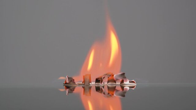 Paper inscription FIRE burns. Flame concept, abstract fire with flakes of spark. Concept of fire