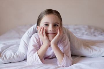 Cute little girl in bed woke up in the morning
