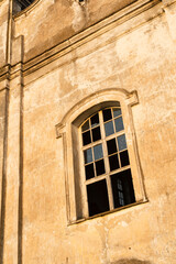 Fototapeta na wymiar The window of an old church in the rays of the evening sun