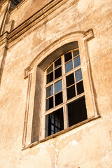 The window of an old church in the rays of the evening sun