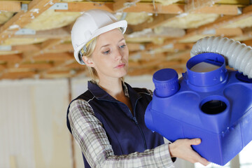 apprentice looking at blue ventilation box