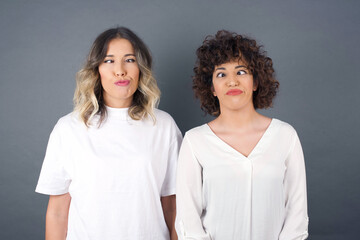 Funny comic girl crosses eyes, puts lips, makes grimace, foolishes after all day studying. Clueless woman nerd with awkward expression has fun alone, plays fool.