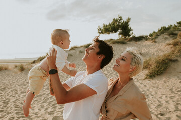 a couple with a baby at the beach