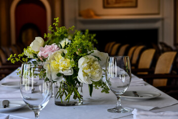 Empty water glasses on a table and a vase with flowers