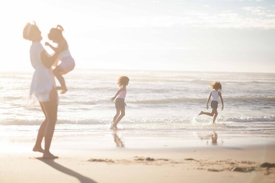 a mother and daughters at the beach
