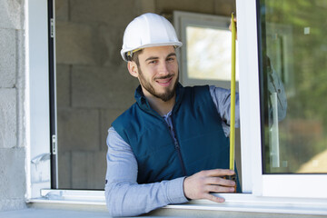 worker measuring the size of the window