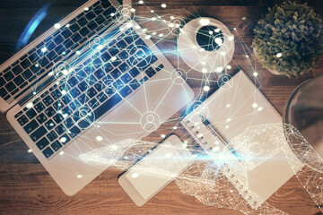 Social network hologram drawings over computer on the desktop background. Top view. Double exposure.