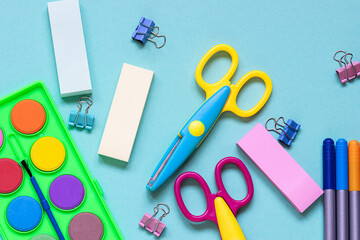 Flat lay overhead view of bright stationery equipment on blue background. Back to school concept.