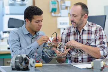 two men repairing electronic device