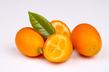 Top view of bunch of fresh kumquats in the organic food market. Some kumquats is cutted.