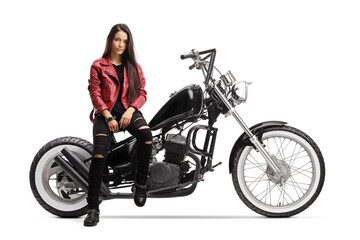 Naklejka na ściany i meble Female biker with a helmet and a leather jacket sitting and posing on a chopper motorbike