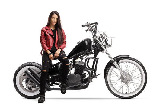 Female biker with a helmet and a leather jacket sitting and posing on a chopper motorbike