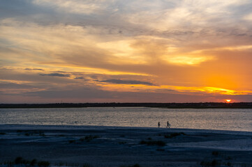 Fototapeta na wymiar Beach Sunset with Walker Silhouettes