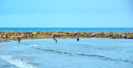 People on the beach during summer day in Cambrils, Spain.