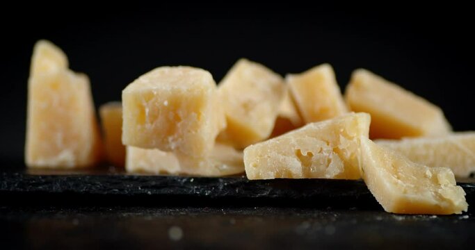 Pieces of Parmesan cheese on a stone Board rotate slowly.