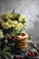  Breakfast Pancakes with  Cherries, Homemade American pancakes served withfresh cherry on a wooden background, sweet dessert 