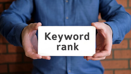 Keyword rank seo - concept in the hands of a young man in a blue shirt