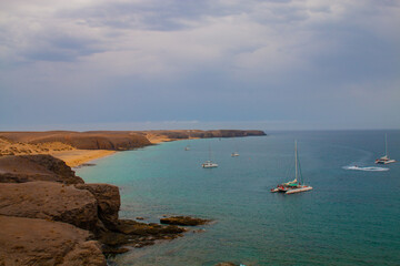 Beautiful beach on the island of Lanzarote in the village Playa Blanca. With Turquoise ocean  Sandy beach surrounded by volcanic mountains / Atlantic Ocean and wonderful Papagayo beach. Lanzarote. 