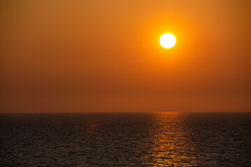 Fototapeta na wymiar 水平線に沈んでいく夕陽と輝く海
