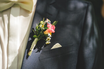 Close up of wedding boutonniere flower on groom's suit. Colorful posy on lapel of jacket. Blue / white dress combination. Wedding day concept. - obrazy, fototapety, plakaty