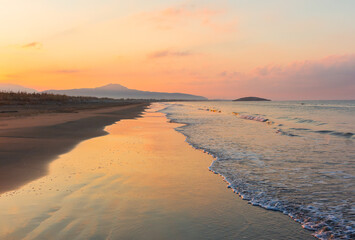 Picturesque Mediterranean seascape in Turkey. Amazing sunrise on Patara beach, Mugla Province. 
Morning orange clouds reflected in calm water.