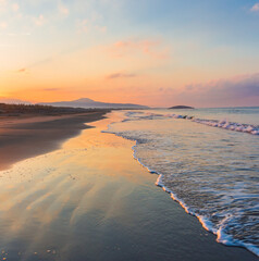 Picturesque Mediterranean seascape in Turkey. Amazing sunrise on Patara beach, Mugla Province. 
Morning orange clouds reflected in calm water.
