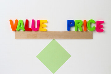 Text made in multicolored magnetic letters. VALUE PRICE. White wooden
