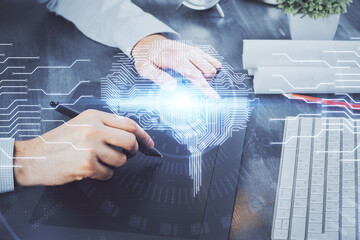 Double exposure of man's hand holding and using a digital device and brain hologram drawing. Data...