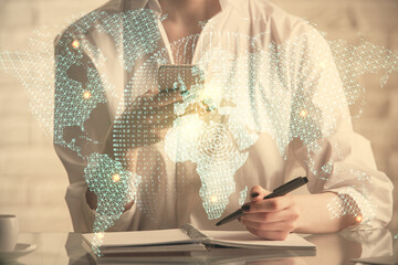 Double exposure of business theme sketch hologram and woman holding and using a mobile device.