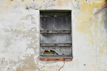 Boarded building window with burnt discolored planks. 