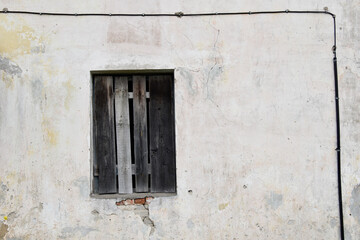 Boarded building window with burnt discolored planks. 