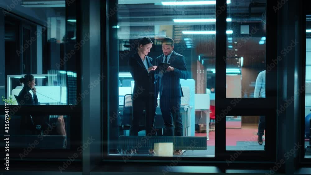 Aufkleber footage from outside: businesswoman and businessman in a suit working on a tablet computer in the of
