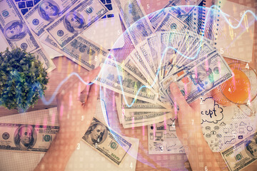 Multi exposure of financial graph drawing hologram and USA dollars bills and man hands. Analysis concept.