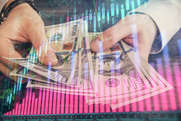 Multi exposure of financial graph drawing hologram and USA dollars bills and man hands. Analysis concept.