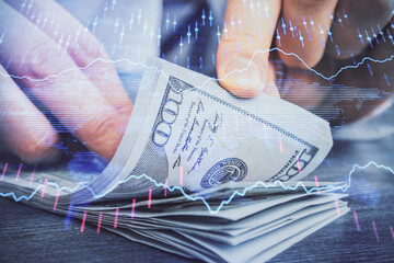 Multi exposure of forex graph drawing hologram and USA dollars bills and man hands. Technical Analysis concept.