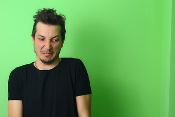 young man or guy on a light green background. Emotion of disgust