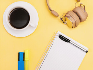 Planner Flat lay photo with copy space Notebook, colorful markers, headphone and cup of black coffee on yellow background