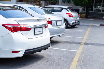Fototapeta na wymiar White and silver car parking in car park lot on daytime.