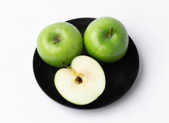Fresh green apples in a dish on white background