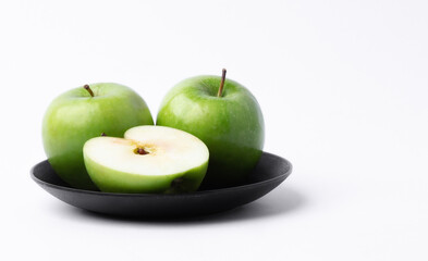 Fresh green apples in a dish on white background