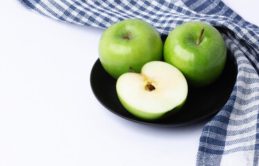 Fresh green apples in a dish on white background