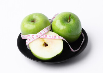 green apple with measuring tape on white background, healthy food concept