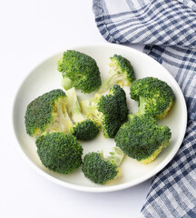 fresh broccoli in a dish on white background