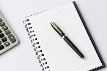 Work space on white desk with equipment office of note book, pen, calculator, Top view and copy space