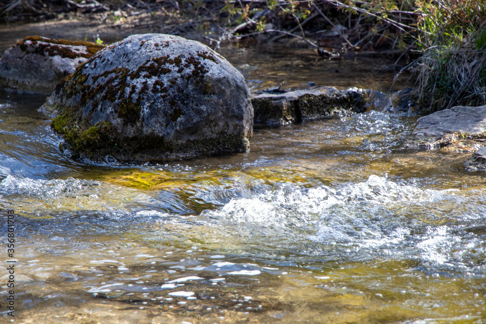 Wall mural water flowing over rocks in the river