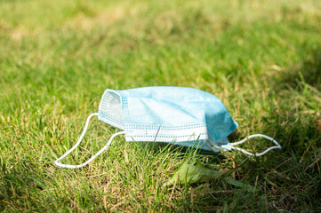 used medical mask thrown onto grass