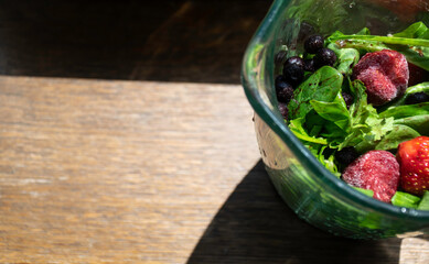 Picture of blender with fruits and vegetables inside before making smoothie.