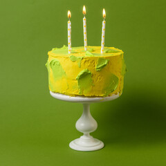 yellow cake with green brush strokesand candles