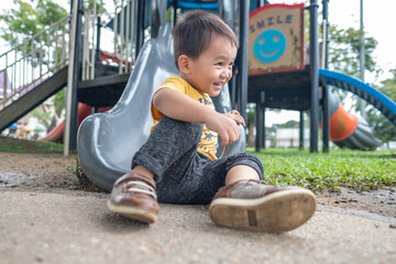 little boy smiling and playing on kid playground