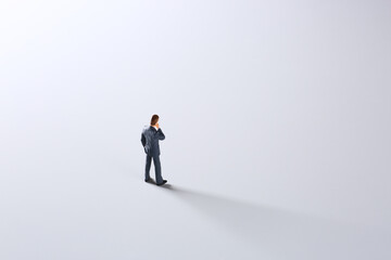 Fototapeta premium 白背景で考えるミニチュア人形